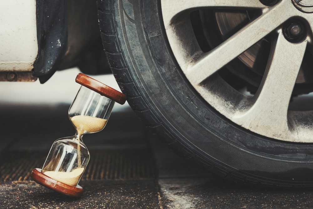 hourglass beneath car wheel indicates how long to file claim or lawsuit