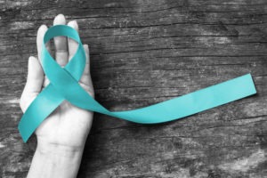 Teal Ribbon in Woman’s Hand To Represent Sexual Assault Awareness