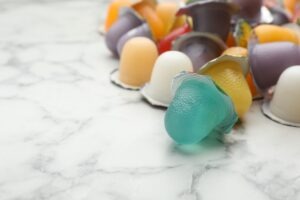 Assorted varieties of fruit jelly cups lay playfully on top of a counter.