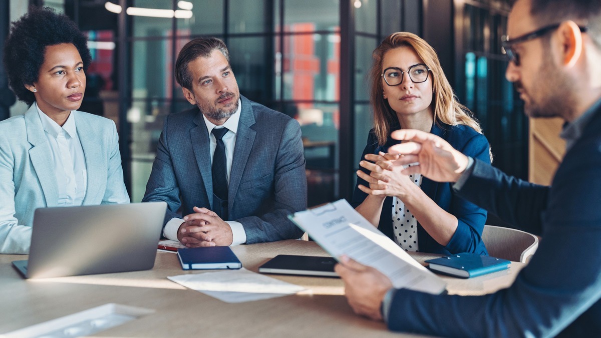 four-individuals-seated-at-a-conference-table