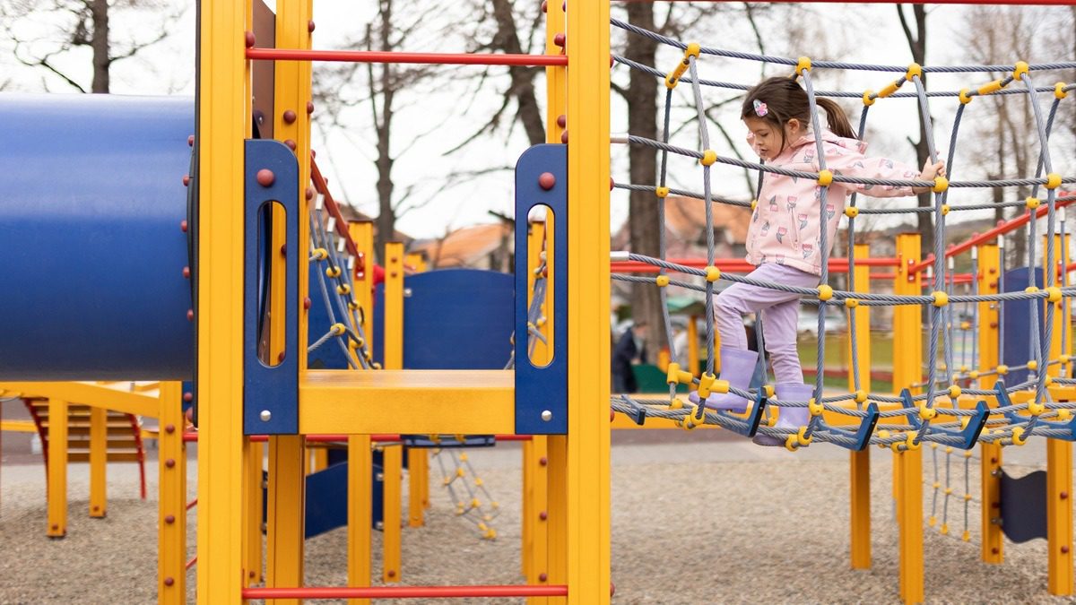 young-girl-playing-on-playgroujnd-equipment