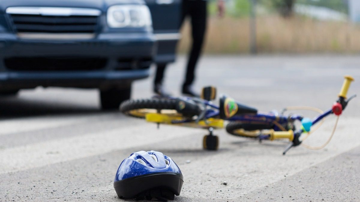 bicycle-and-helmet-on-the-cement-near-car