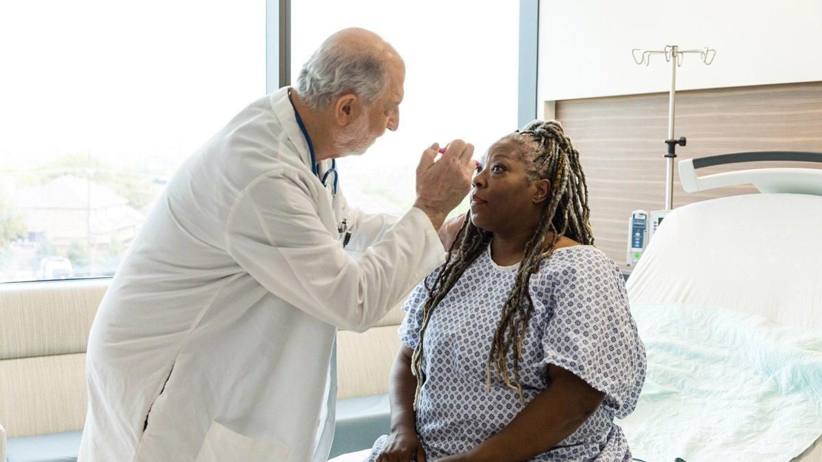 doctor-checking-pupils-of-patient-in-hospital
