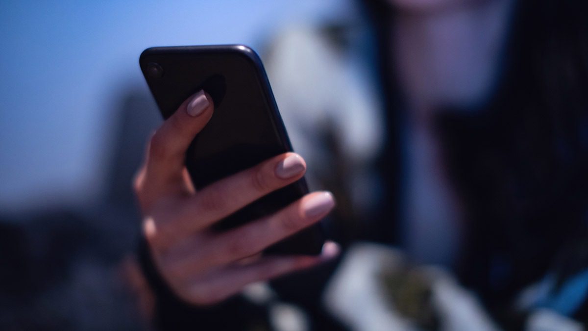 individual-checking-phone-messages-in-shadow