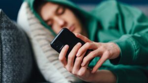 individual-lying-on-their-side-looking-at-cell-phone