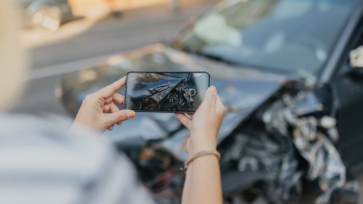 individual-taking-a-cell-phone-photo-of-a-wrecked-car