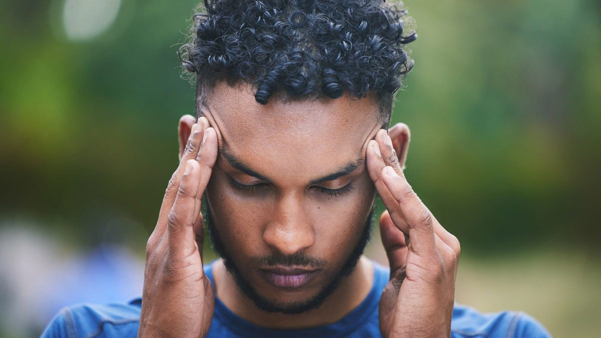 man-looking-down-with-hands-on-his-temples