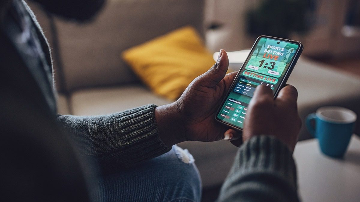 man-sitting-down-and-placing-a-bet-on-his-cell-phone
