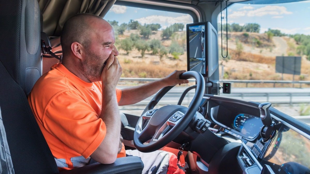 man-yawning-behind-the-wheel-of-a-truck