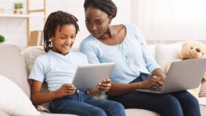 mother-looking-over-childs-shoulder-while-on-a-tablet