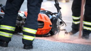 view-of-motorcycle-and-helmet-in-road-with-first-responders