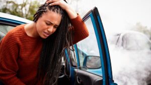 women-holding-her-head-and-exiting-car