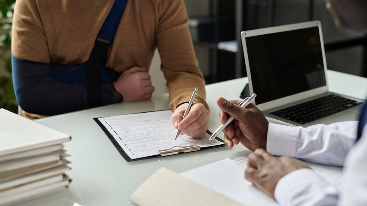 Close-up-of-man-filling-in-medical-insurance-form