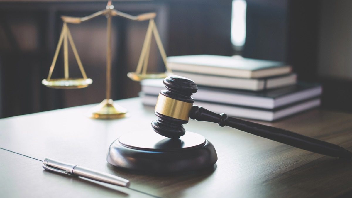 Scales-of-justice-and-gavel-on-wooden-table