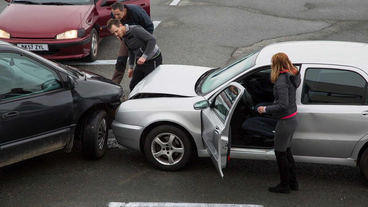 Two-men-looking-at-car-collision-on-road