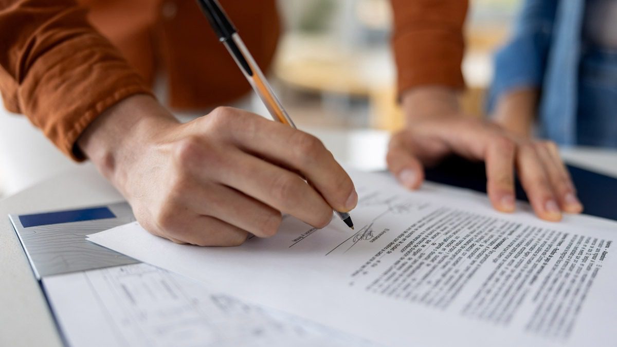 closeup-of-person-signing-paperwork