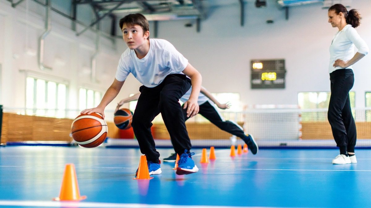 young-male-dribbling-basketball-in-gym