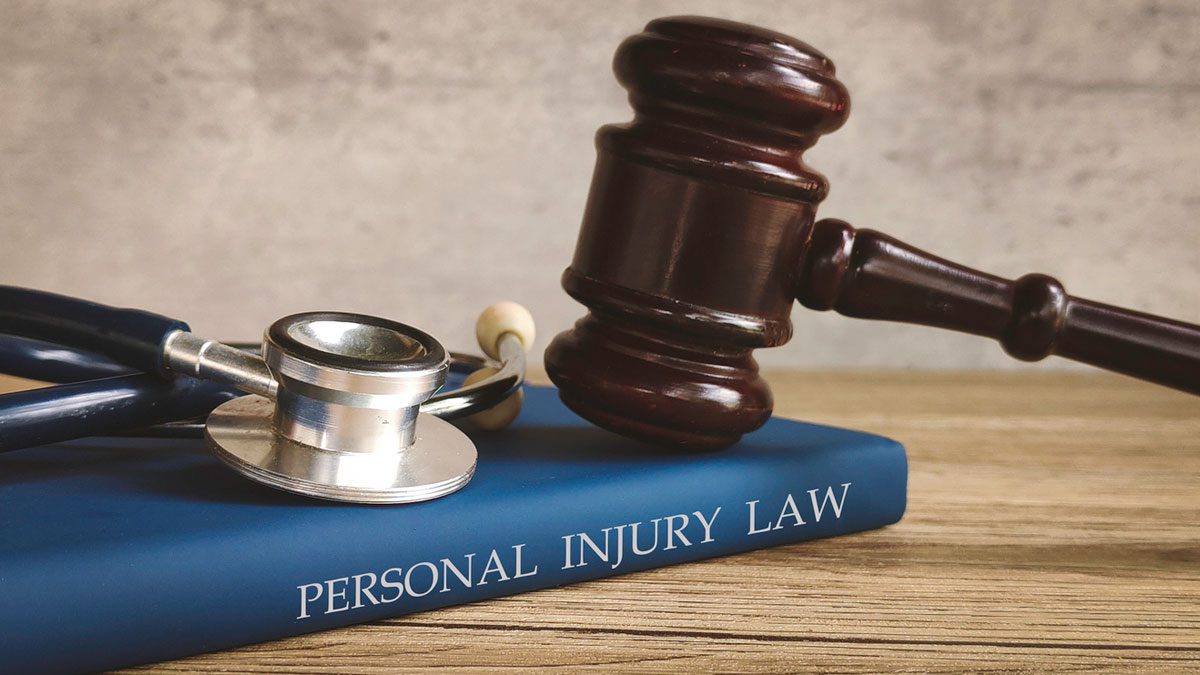 Gavel and stethoscope on a book about personal injury law
