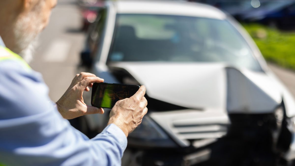 Man taking photos of his wrecked car