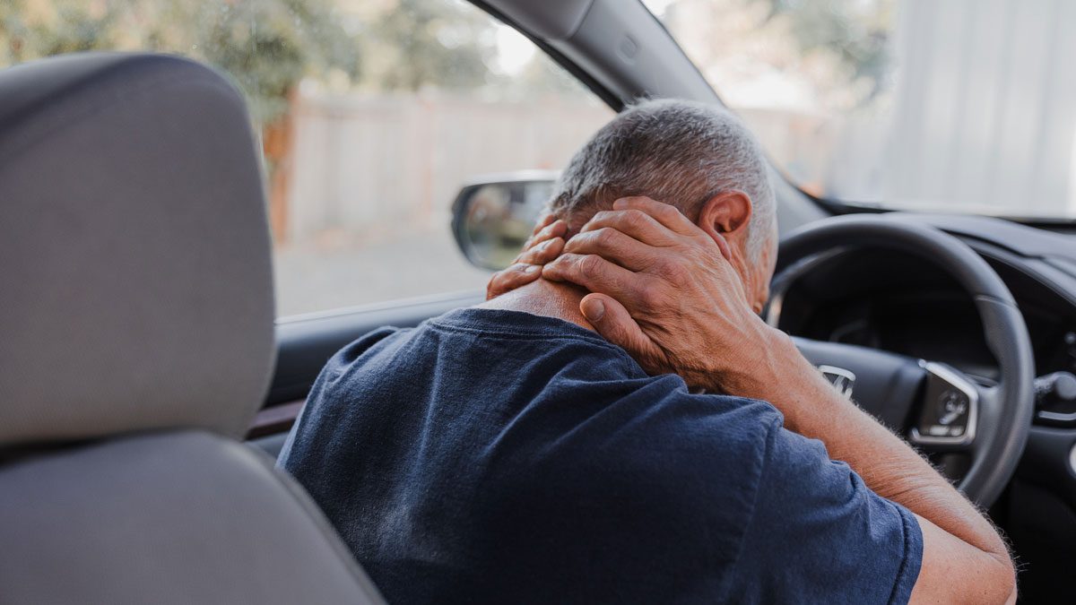 Middle-aged man with neck pain in car