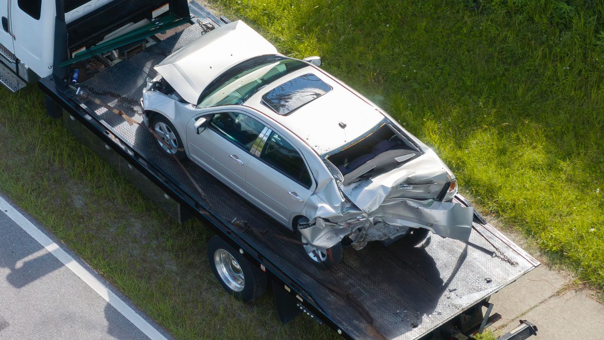 Tow truck hauling crashed vehicle from car accident site