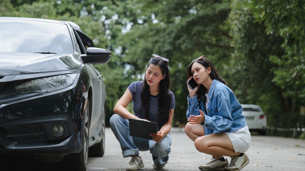 Women examining damaged vehicle