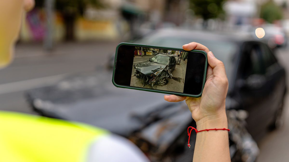 individual taking photo of crashed car