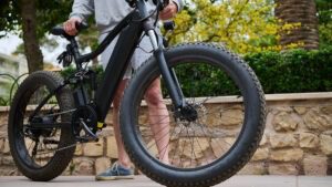 individual-walking-electric-bike-on-sidewalk