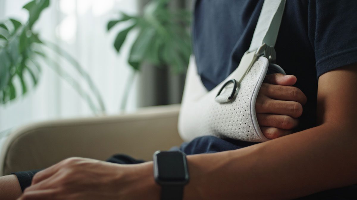 man-sitting-in-chair-with-arm-in-a-sling