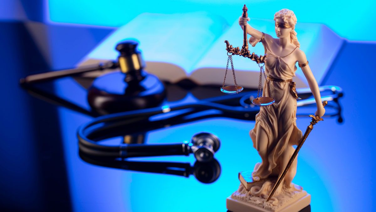 stethoscope in background with justice statue in front