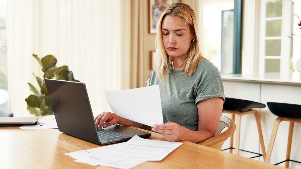 woman-with-laptop-and-paperwork-at-a-table