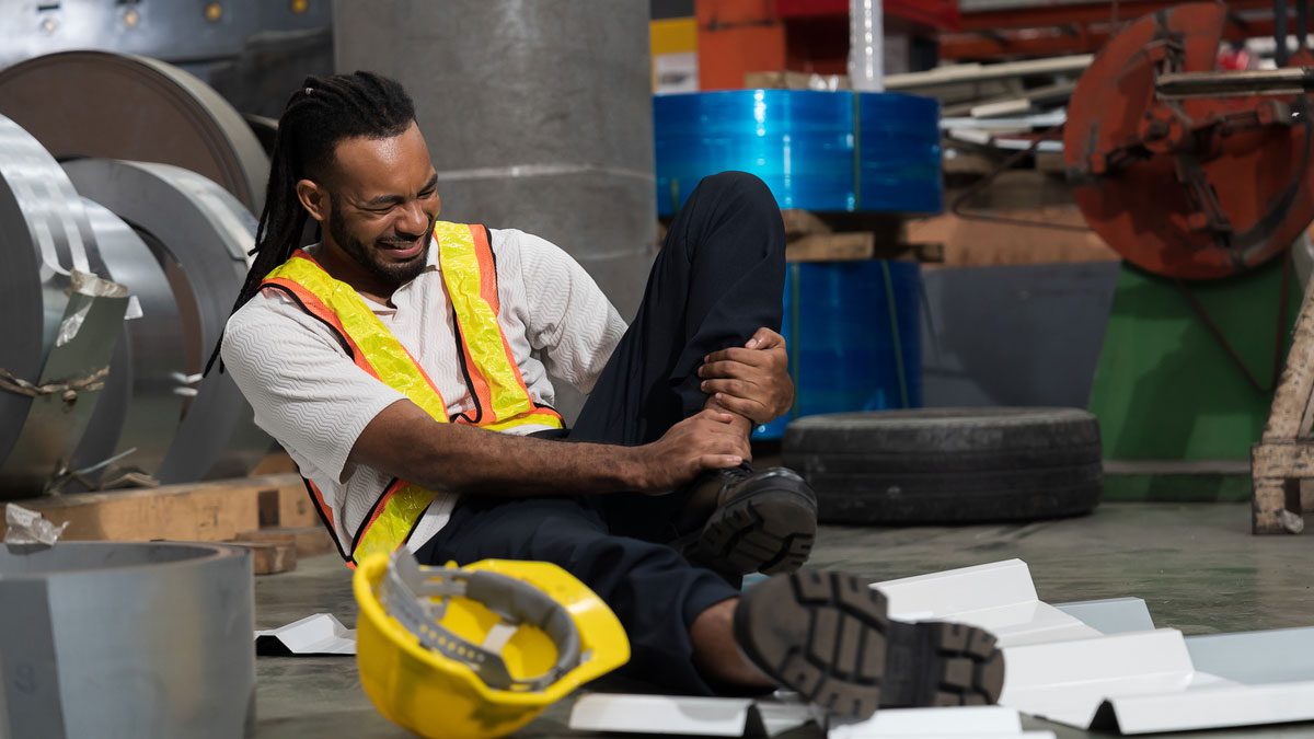 worker holding leg in pain on floor