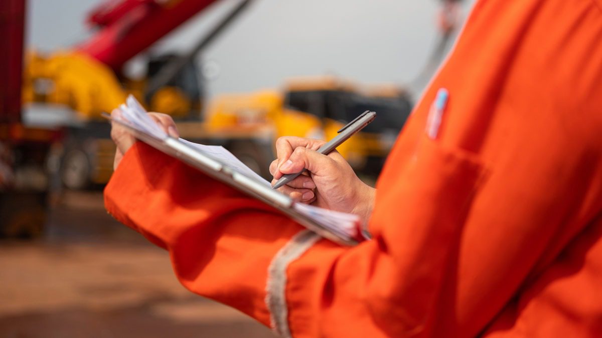 worker-making-notes-on-clipboard-at-construction-site