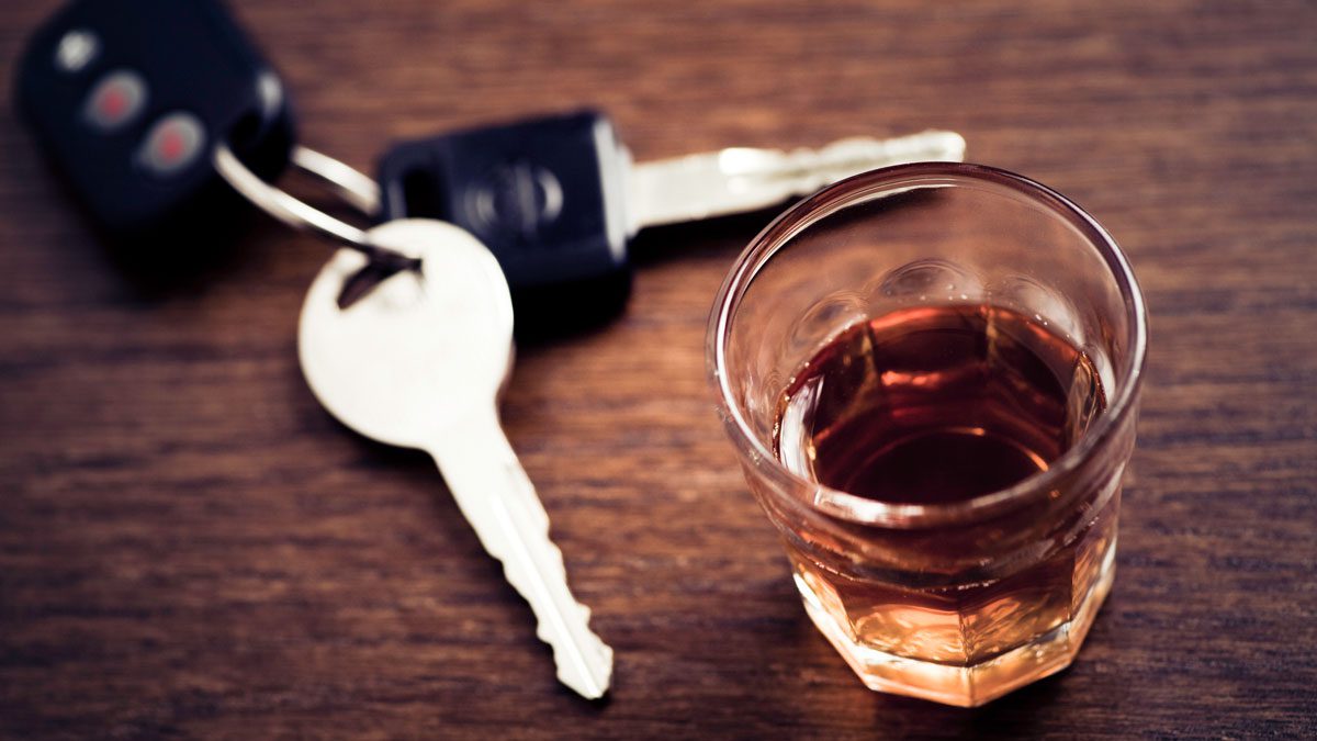 overhead-shot-of-keys-next-to-glass-of-alcohol
