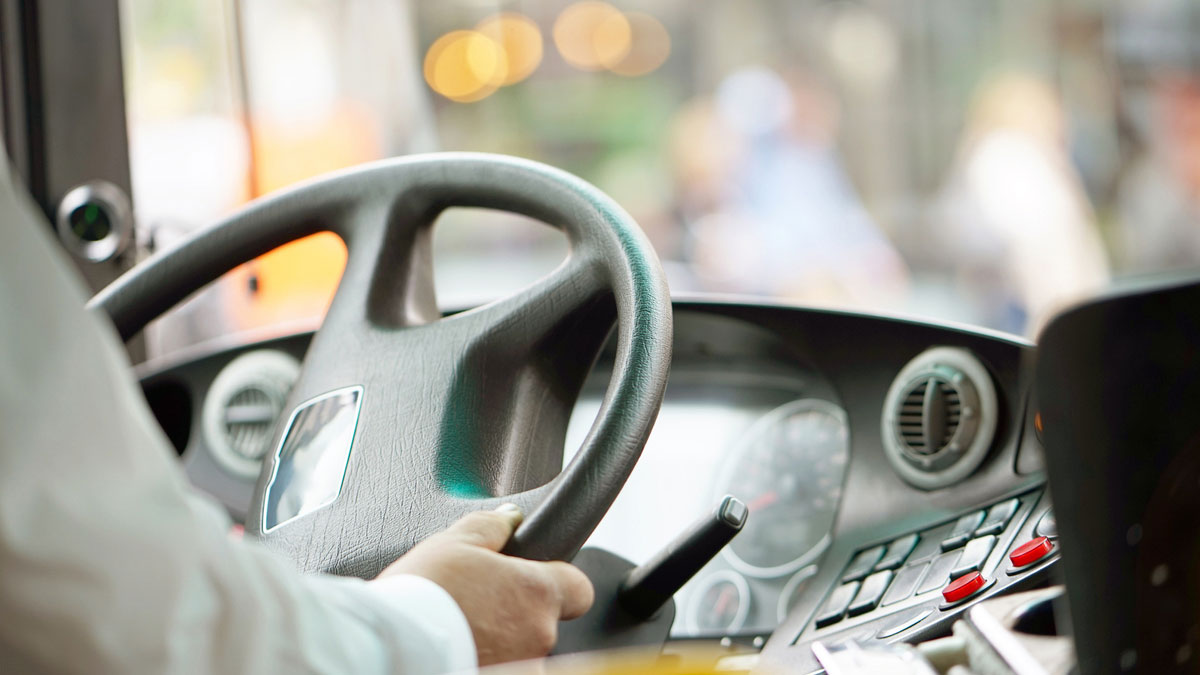 side-rear-view-of-bus-driver-at-wheel