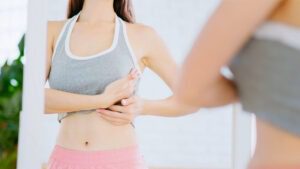 woman-examining-chest-area-in-mirror