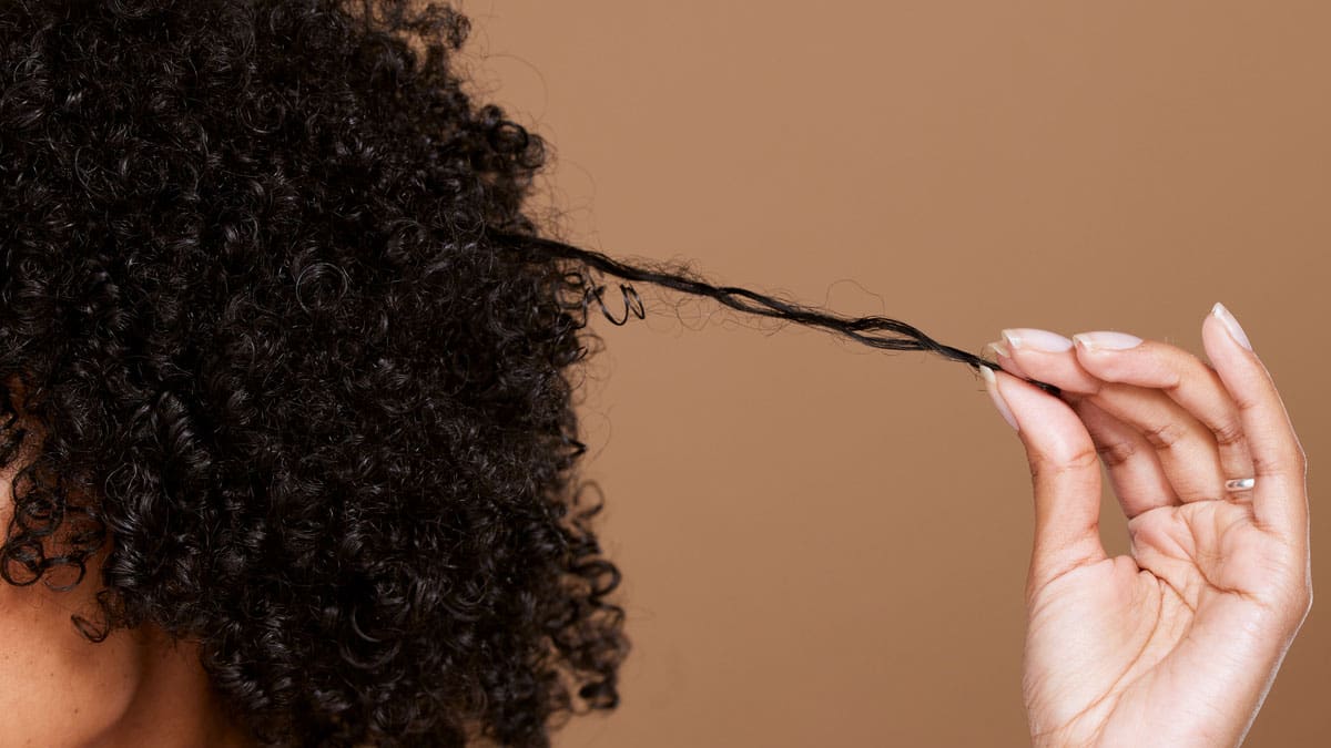female-puling-strands-of-natural-hair