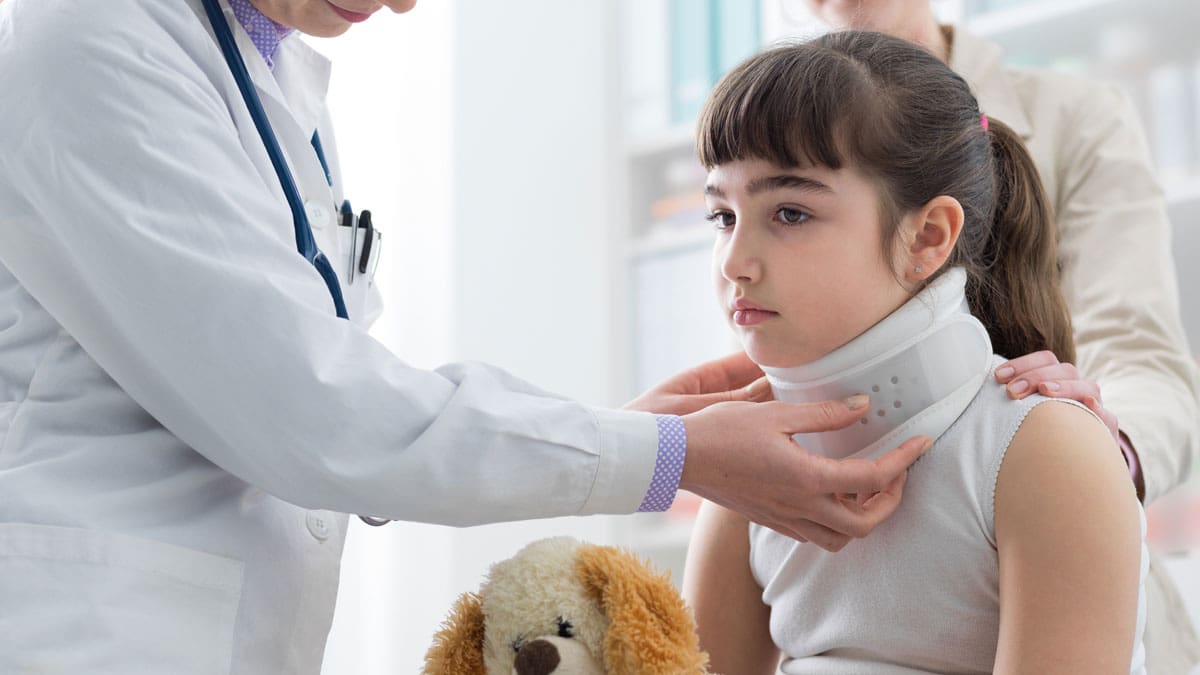 girl-getting-neck-brace-fitted-at-doctor's-office