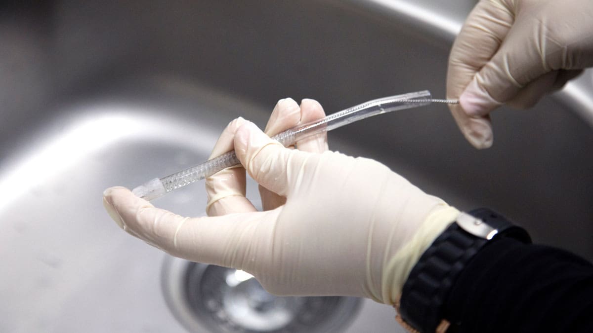 gloved-hand-handling-port-over-sink