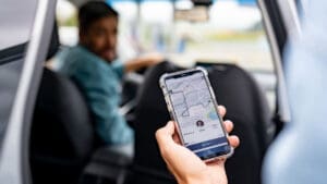 person-checking-rideshare-app-before-entering-car