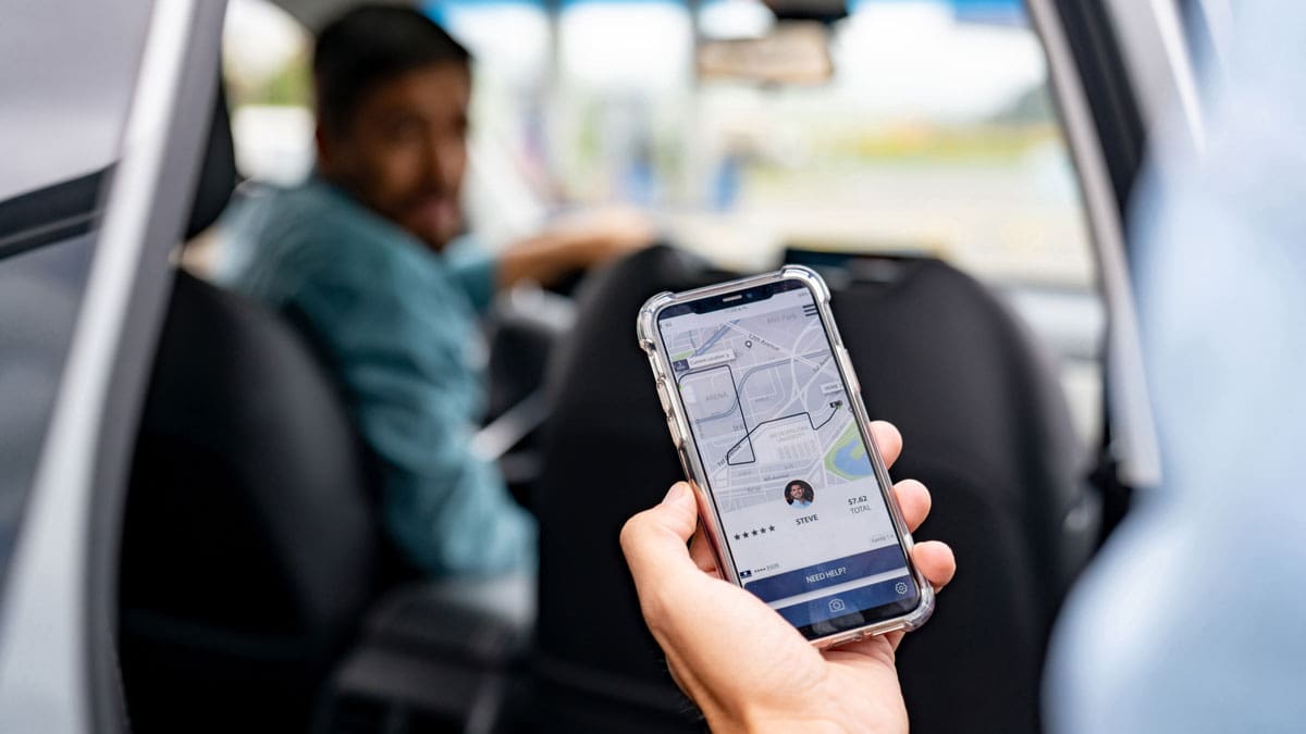 person-checking-rideshare-app-before-entering-car