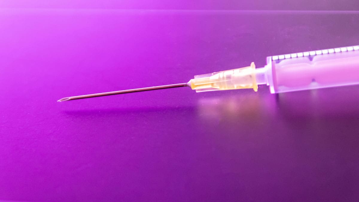 syringe-on-purple-background