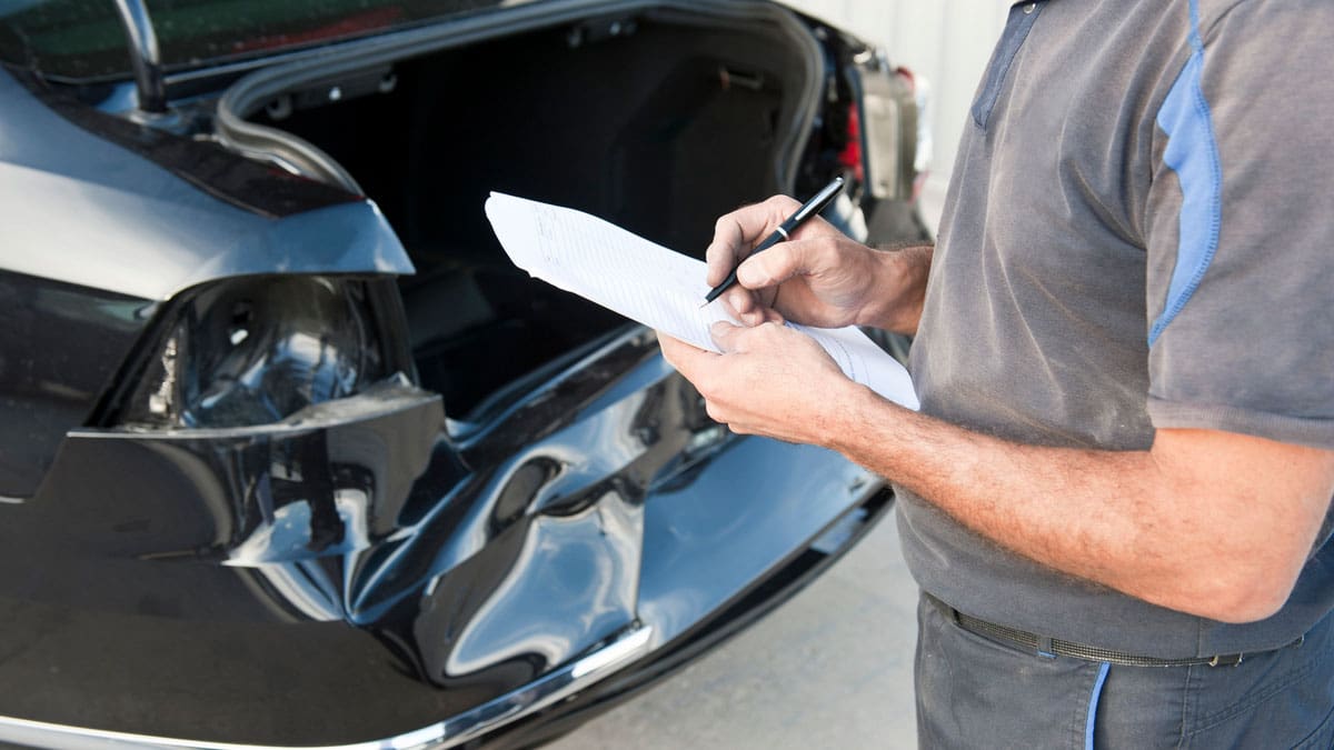 mechanic-or-adjustor-looking-at-damage-from-rear-end-accident