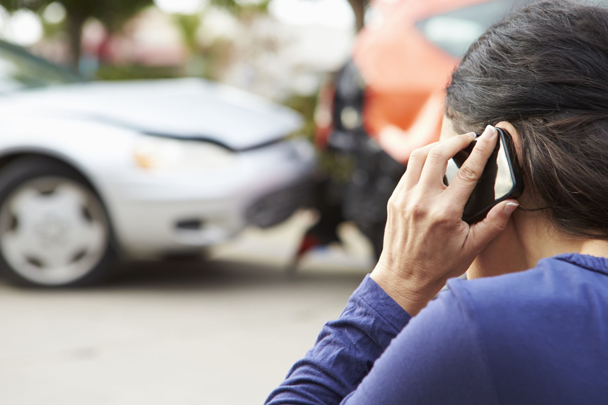 woman on cell phone after car accident