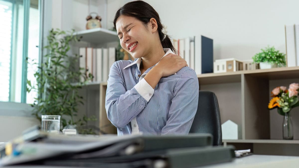 woman-seated-at-desk-with-neck-or-shoulder-pain
