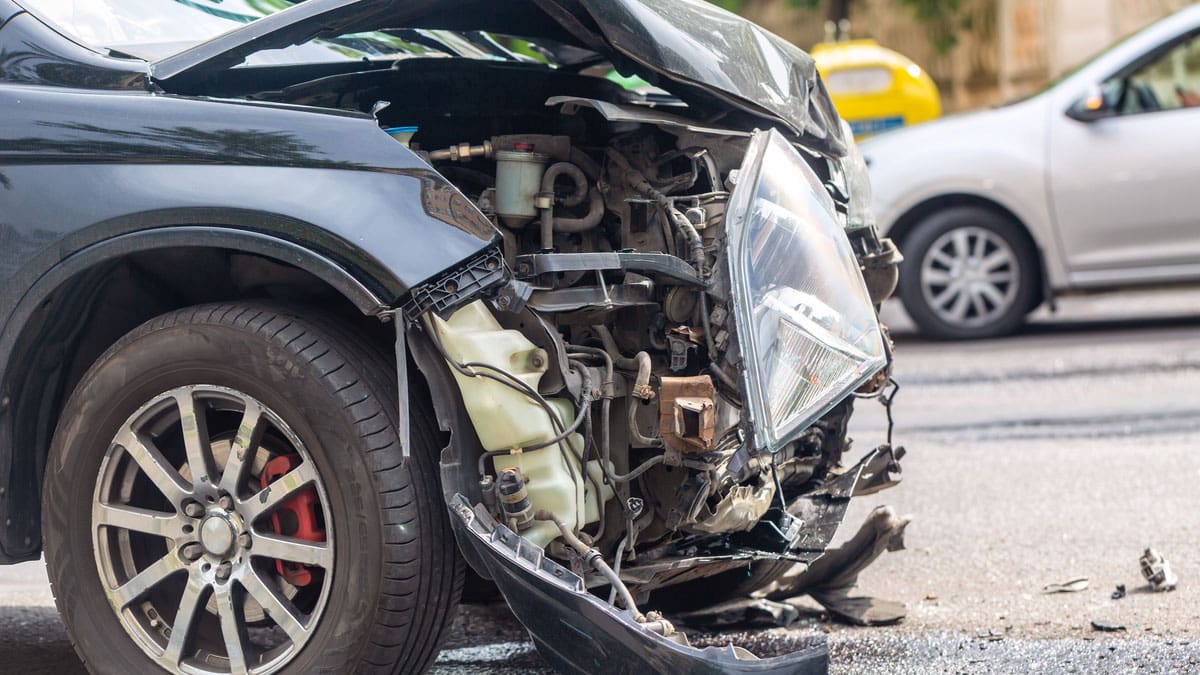 SUV-with-heavy-front-end-damage-in-the-road-after-a-crash