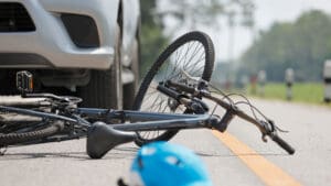 bicycle-and-helmet-on-the-road-in-front-of-a-car-after-a-collision