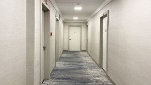 empty-hotel-hallway-with-an-exit-sign-at-the-far-end