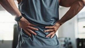 man-holding-his-lower-back-with-both-hands