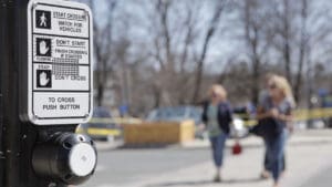 pedestrian-crossing-signal-box-on-a-pole-with-people-walking-behind